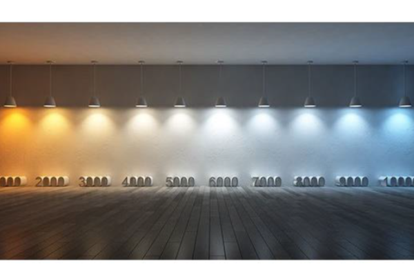 Eine weiße Wand in deren Nähe zehn Lampen nebeneinander von der Decke hängen. Jede Lampe leuchtet in einer anderen Lichttemperatur (von fast orange mit eintausend Kelvin über weiß mit sechstausend Kelvin bis bläulich mit zehntausend Kelvin)