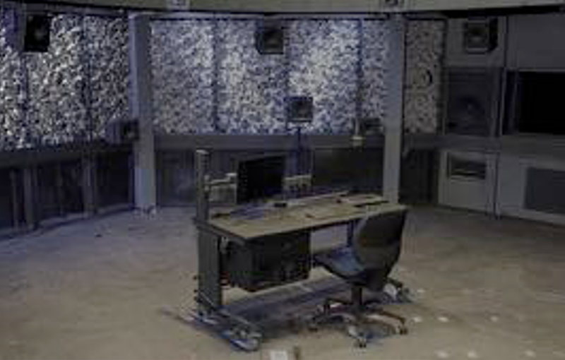 exaktes drei D Modell des Spacial audio labs, ein fast runder Raum, mit vieren Lautsprechern und einem Schreibtisch mit Stuhl in der Mitte